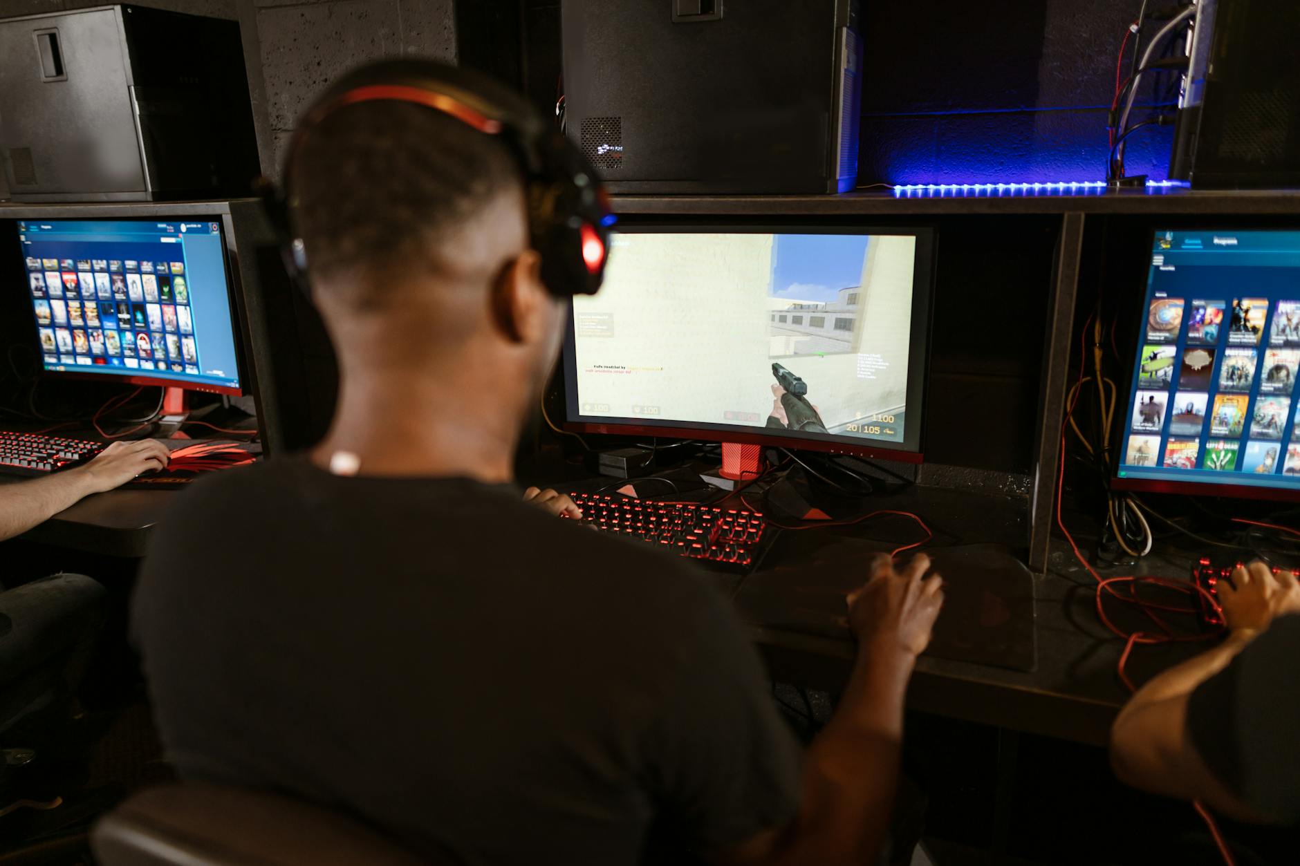 Đội tuyển FPS thi đấu trong nhà thi đấu với nhiều màn hình và góc nhìn chiến thuật